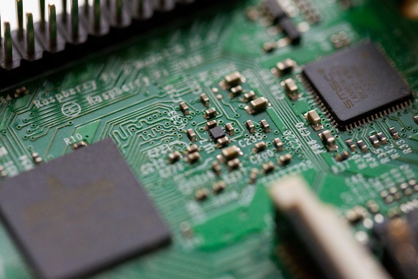 Close-up of a green printed circuit board with surface-mounted chips